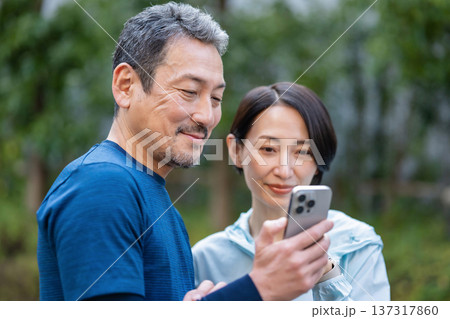 スマホを操作する夫婦 スマホを操作する夫婦 137317860