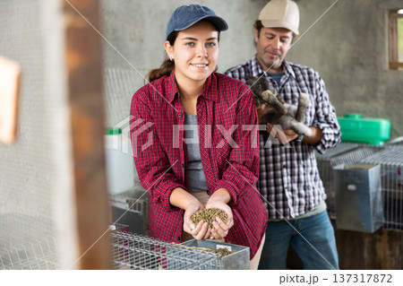 Married couple feeds and cares for rabbits on farm 137317872