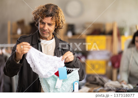 Positive male client choosing new panties in lingerie store 137318077