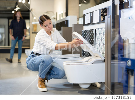 Confident woman picking out new toilet in hardware store Confident woman picking out new toilet in hardware store 137318155