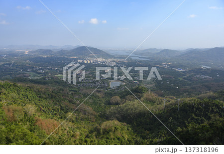 Aerial view of Sanya city with a sea bay surrounded by mountains on Hainan Island in China Aerial view of Sanya city with a sea bay surrounded by mountains on Hainan Island in China 137318196