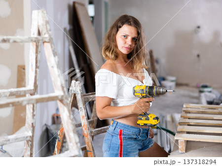 Portrait of attractive woman with drill 137318294