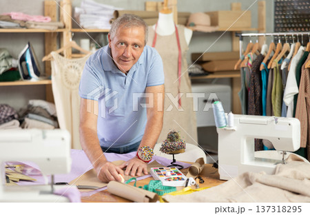 Mature man making markings on paper Mature man making markings on paper 137318295