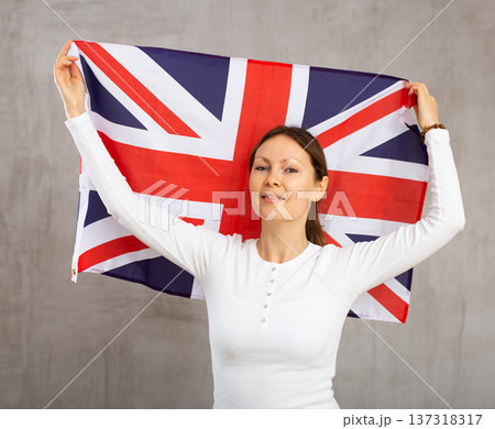 Attractive female football fan holding Great Britain flag Attractive female football fan holding Great Britain flag 137318317