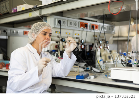 Focused female technician working in research laboratory Focused female technician working in research laboratory 137318323
