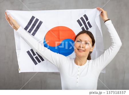 Joyful female fan of favorite team of South Korea with the national flag in her hands Joyful female fan of favorite team of South Korea with the national flag in her hands 137318337