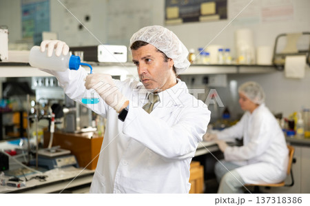 Portrait of an adult male using equipment to work in a laboratory 137318386