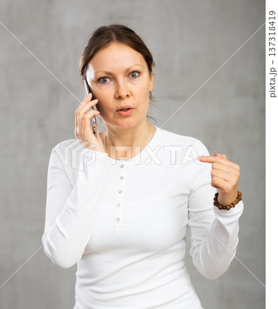 Unhappy annoyed woman argues on phone with fury anger and frustration Unhappy annoyed woman argues on phone with fury anger and frustration 137318419