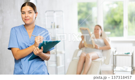 Young female doctor making notes in medical room Young female doctor making notes in medical room 137318457