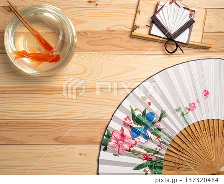 金魚鉢とうちわが置かれた伝統的な日本の夏の机、真上からの俯瞰ショット 137320484
