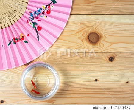金魚鉢とうちわが置かれた伝統的な日本の夏の机、真上からの俯瞰ショット 金魚鉢とうちわが置かれた伝統的な日本の夏の机、真上からの俯瞰ショット 137320487