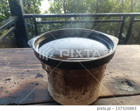 Clay stove metal pot hot water steam outdoor cooking rustic kitchen traditional cooking vessel with steam rising clay stove Clay stove metal pot hot water steam outdoor cooking rustic kitchen traditional cooking vessel with steam rising clay stove 137320863