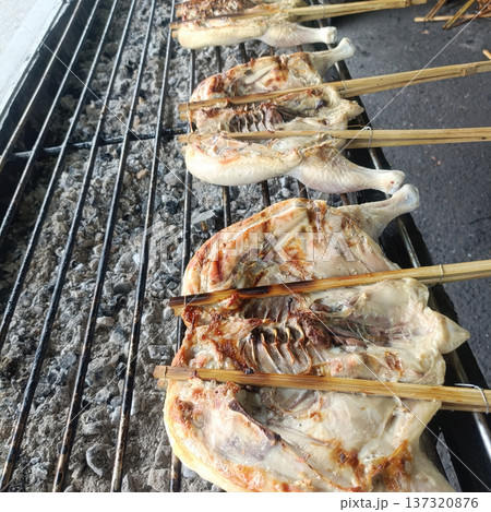 Grilled chicken street food charcoal grill bamboo skewer traditional cooking outdoor market rustic cuisine smoky flavor Grilled chicken street food charcoal grill bamboo skewer traditional cooking outdoor market rustic cuisine smoky flavor 137320876