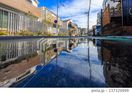 水たまりに青空と住宅街が反射する雨上がりの風景 水たまりに青空と住宅街が反射する雨上がりの風景 137320899