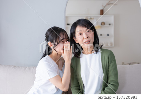 内緒話をする母と娘 137320993