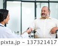 Doctor uses finger pulse oximeter measuring patient man while he sitting in a wheelchair, elderly health checkup, happiness. 137321417