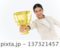 Portrait of Winning businesswoman celebrating with trophy award for success in business isolated on white background. Successful employee holds golden cup. Looking at the camera. 137321457