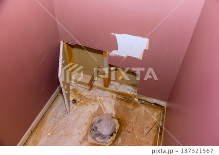 Wall is cut open exposing pipes plumbing for bathroom repair taking place in home. Wall is cut open exposing pipes plumbing for bathroom repair taking place in home. 137321567