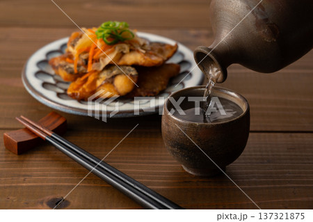 徳利からお猪口に注がれる日本酒とアジの南蛮漬けの晩酌風景 徳利からお猪口に注がれる日本酒とアジの南蛮漬けの晩酌風景 137321875