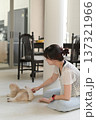 Calm peaceful asian woman sitting comfortable on floor cushion at home improving daily mental health and lifestyle wellness by gently touching friendly cat pet feeling relaxed happy 137321966