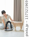 Happy asian woman sitting comfortably on floor at home enjoying wellness and good mental health benefits while playing with friendly pet cat indoors 137321969