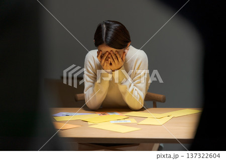 支払いに困り頭を抱える女性 支払いに困り頭を抱える女性 137322604