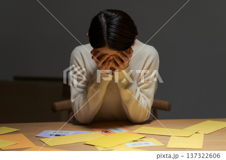 支払いに困り頭を抱える女性 137322606
