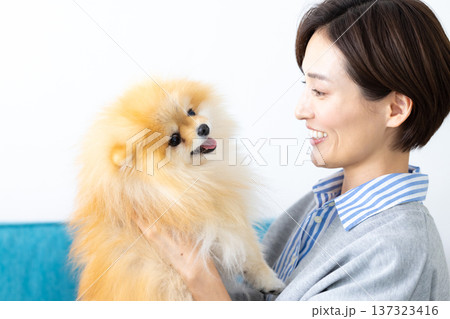 ライフスタイル　愛犬を抱っこしている女性 137323416