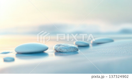 Smooth stones on serene beach with soft waves and pastel hues create tranquil atmosphere 137324902