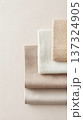 Neutral toned fabric swatches stacked in minimalist arrangement, showcasing texture and softness 137324905