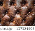 Luxurious close up of tufted brown leather upholstery with visible texture and buttons 137324908