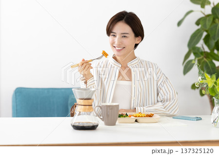 食事　宅配弁当を食べる女性 137325120
