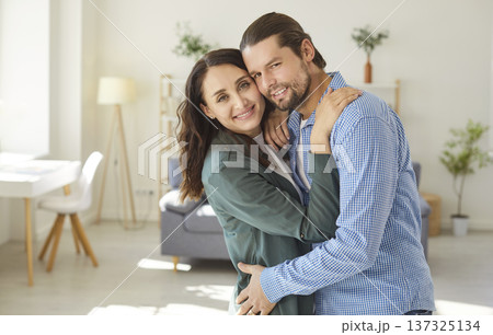 Loving couple in close hug, family celebrate relocation to new modern apartment, husband and wife Loving couple in close hug, family celebrate relocation to new modern apartment, husband and wife 137325134