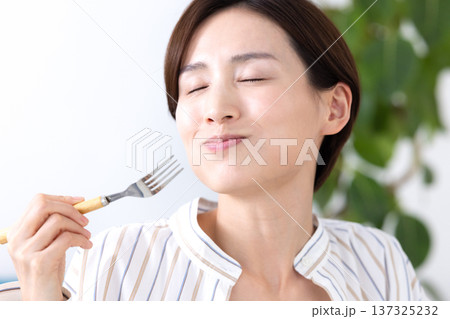 食事 美味しそうに食べている女性 食事 美味しそうに食べている女性 137325232