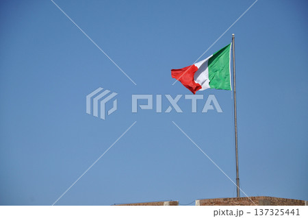 Waving flag of Italy against blue sky 137325441