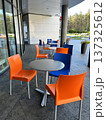 Orange and Blue Chairs and Round Tables in Street Cafe. 137325612