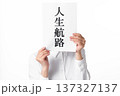 人生航路と書かれた紙を両手で持つ白いシャツを着た人物 137327137
