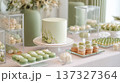Elegant wedding dessert buffet table with matching sage green cake, macarons, and sweet treats 137327364