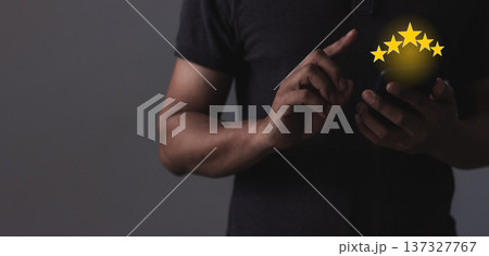 Excellence Review, Young Man hand holding Smart Phone with five star to review and give 5 stars with very good results in service, Good review 5 star rating choice feedback 137327767