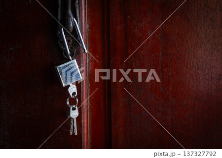 House key left hanging on an empty door symbolizes abandonment, separation, loneliness, and emotional loss. House key left hanging on an empty door symbolizes abandonment, separation, loneliness, and emotional loss. 137327792