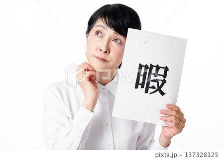 暇と書かれた紙を持ち暇そうに佇む白いシャツを着たシニア女性 暇と書かれた紙を持ち暇そうに佇む白いシャツを着たシニア女性 137328125