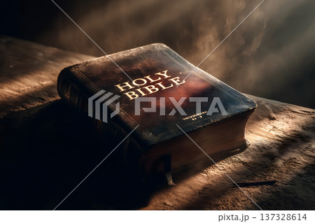 Ancient holy book rests on rustic surface. Warm light beams through smoky air. Gilded lettering glows with reverence. Worn cover suggests timeless devotion. Texture details emphasize aged significance Ancient holy book rests on rustic surface. Warm light beams through smoky air. Gilded lettering glows with reverence. Worn cover suggests timeless devotion. Texture details emphasize aged significance 137328614