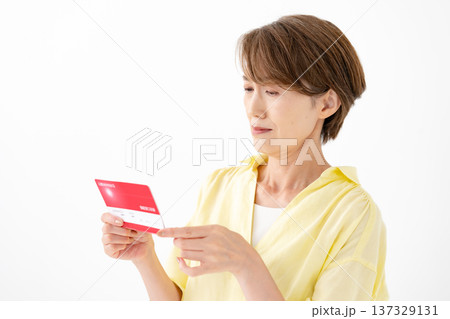 通帳を見て悩む女性 通帳を見て悩む女性 137329131