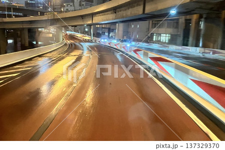 雨の夜の都市高速道路カーブと濡れた路面の光の反射 雨の夜の都市高速道路カーブと濡れた路面の光の反射 137329370