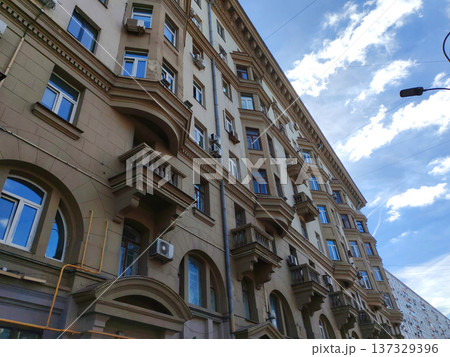 A close-up view of a historic residential building with arched details and air conditioning units on its facade. It highlights the adaptation of old architecture to modern urban needs. A close-up view of a historic residential building with arched details and air conditioning units on its facade. It highlights the adaptation of old architecture to modern urban needs. 137329396