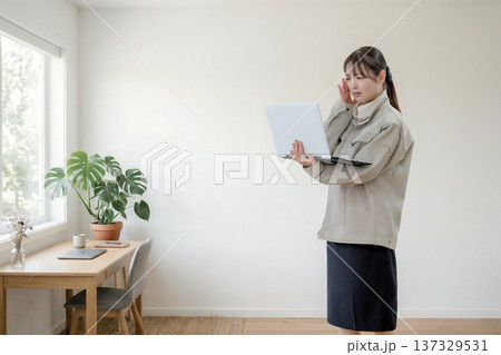 画面を見て表情が強張る作業員女性 137329531