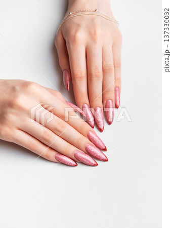Woman hands manicure with long glittery rose gold nails 137330032