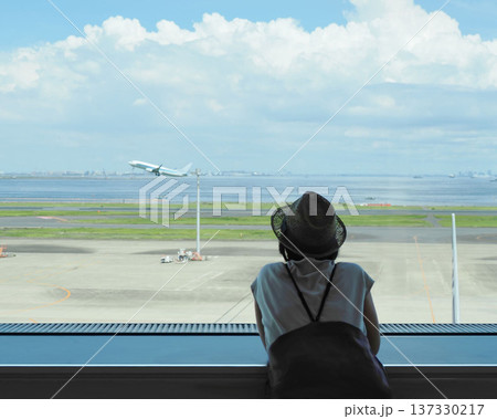 羽田空港の展望ラウンジで離陸する飛行機を眺める女性客の後ろ姿 羽田空港の展望ラウンジで離陸する飛行機を眺める女性客の後ろ姿 137330217