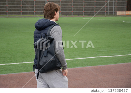 Young man with backpack going to sports field outdoor lifestyle Young man with backpack going to sports field outdoor lifestyle 137330437