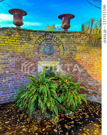 Wide-angle of ornamental wall featuring planters and stone pedestal at sunset Wide-angle of ornamental wall featuring planters and stone pedestal at sunset 137331396